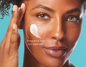 Young woman applying a small amount of Curél moisturiser to her cheek